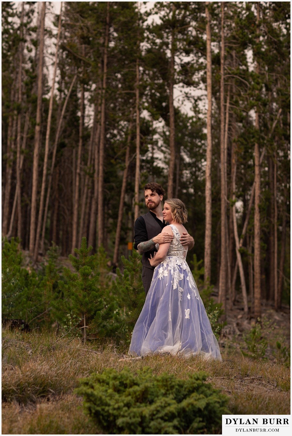 mountain adventure elopement wedding colorado newlywed couple looking out at sunset and wildfires