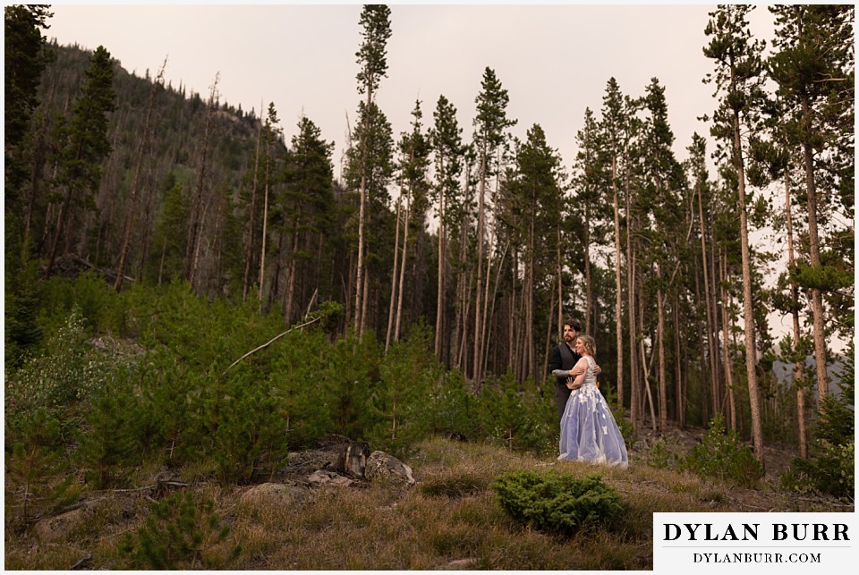 mountain adventure elopement wedding colorado newlywed couple together in tall thin pine trees