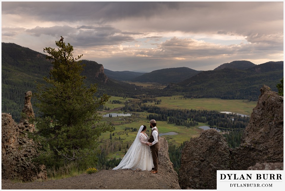 pagosa springs elopement couple looking out over large green mountain valley