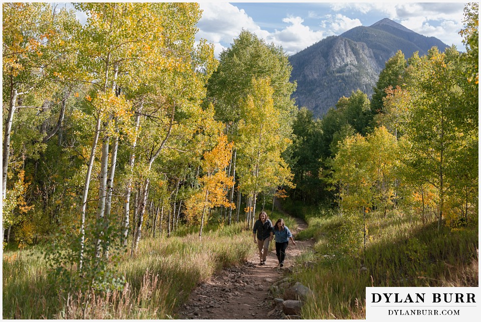 fall mountain engagement photo session couple walking together with giant mountain in distance