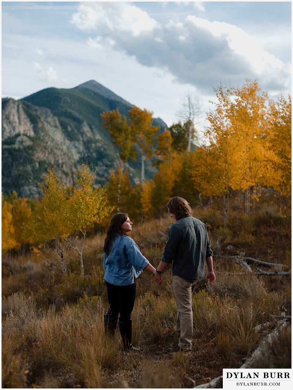 fall mountain engagement photo session couple hand in hand during fall in the mountains