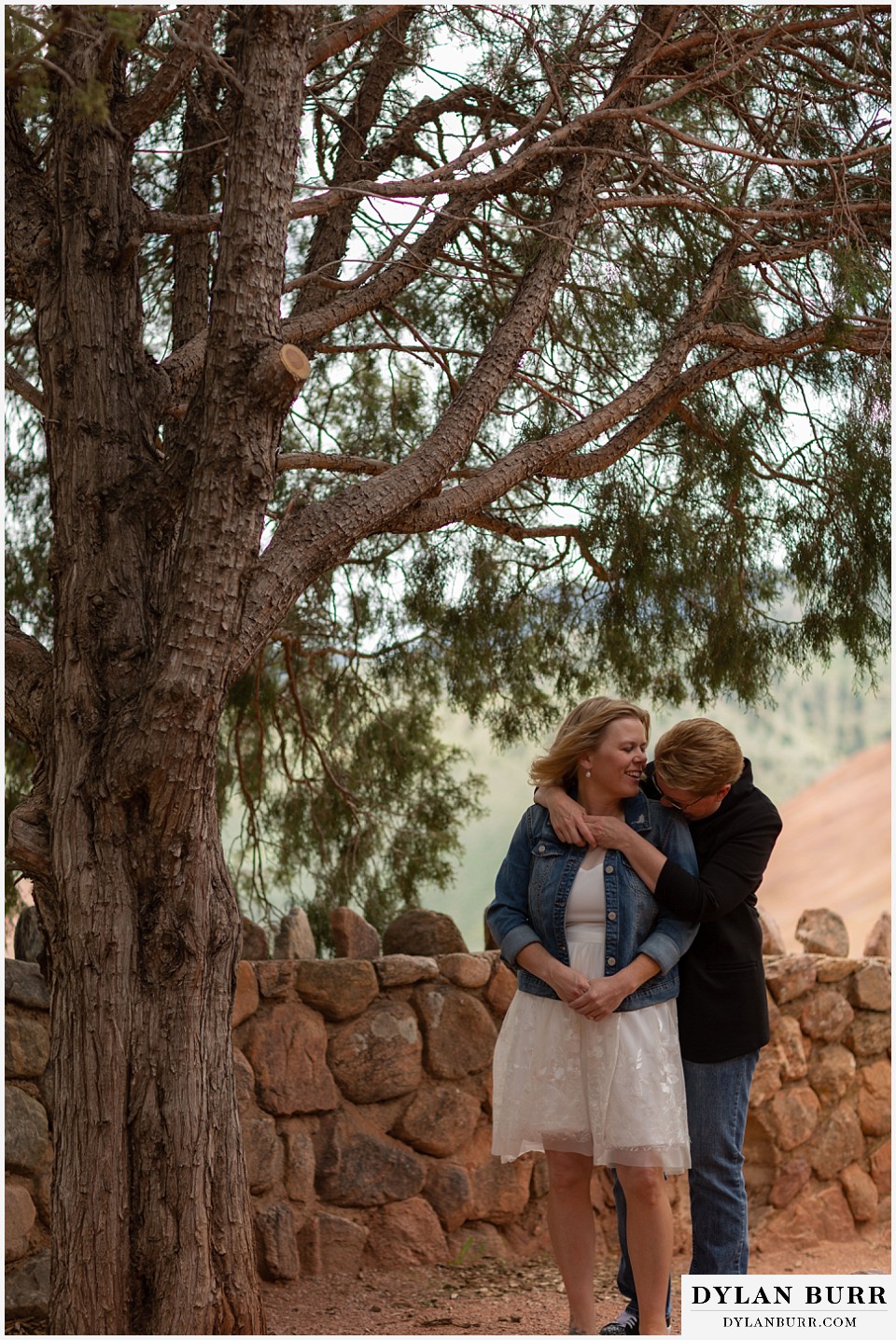 red rocks wedding morrison colorado lesbian couple walking by tall interesting pine tree