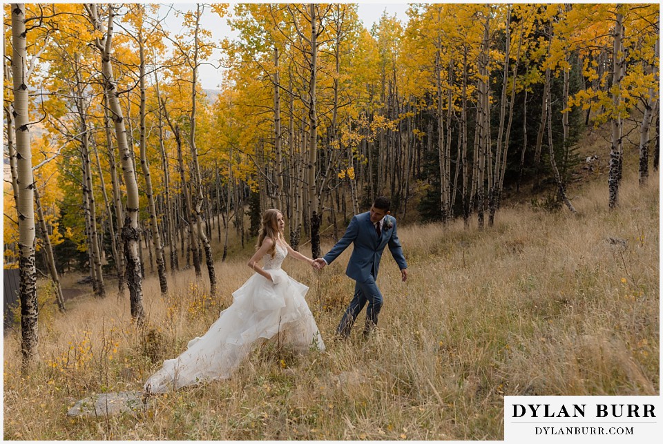 rhize weddings colorado bride and groom walking together in the fall aspen trees
