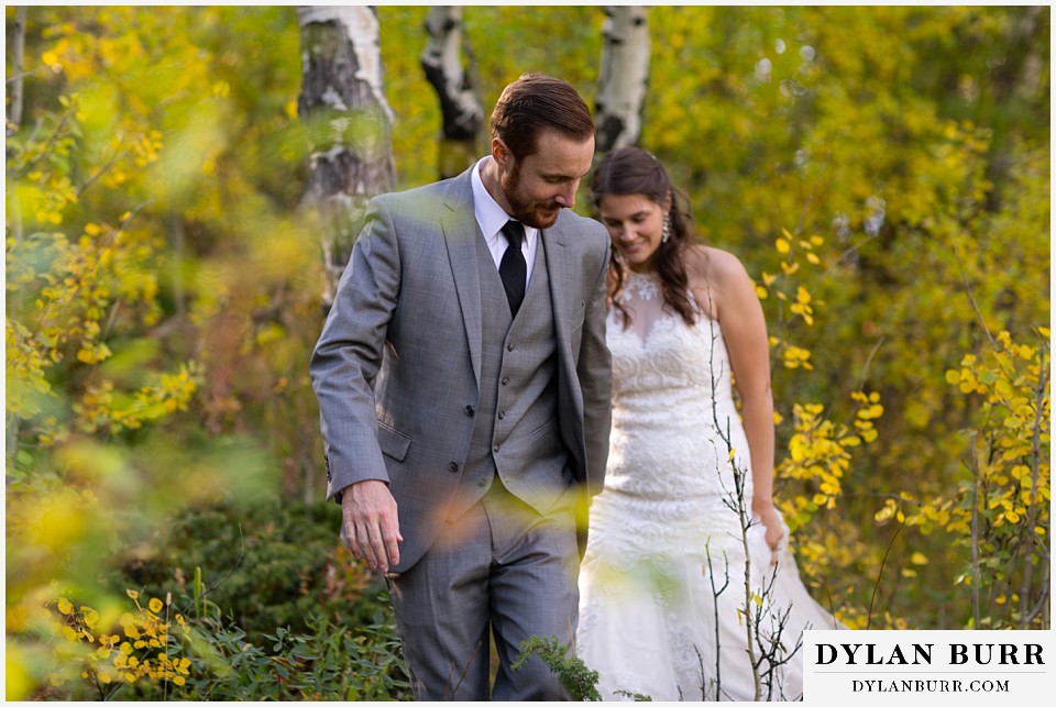 rocky mountain national park elopement wedding groom leading bride in aspen forest