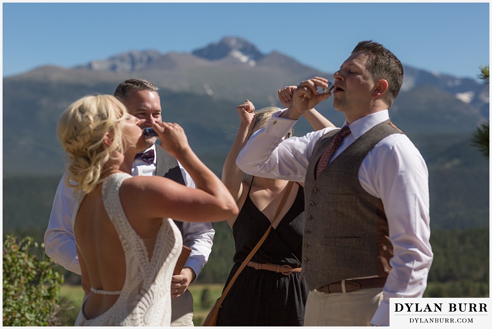 rocky mountain national park wedding elopement bride and groom celebrating with a shot of whiskey