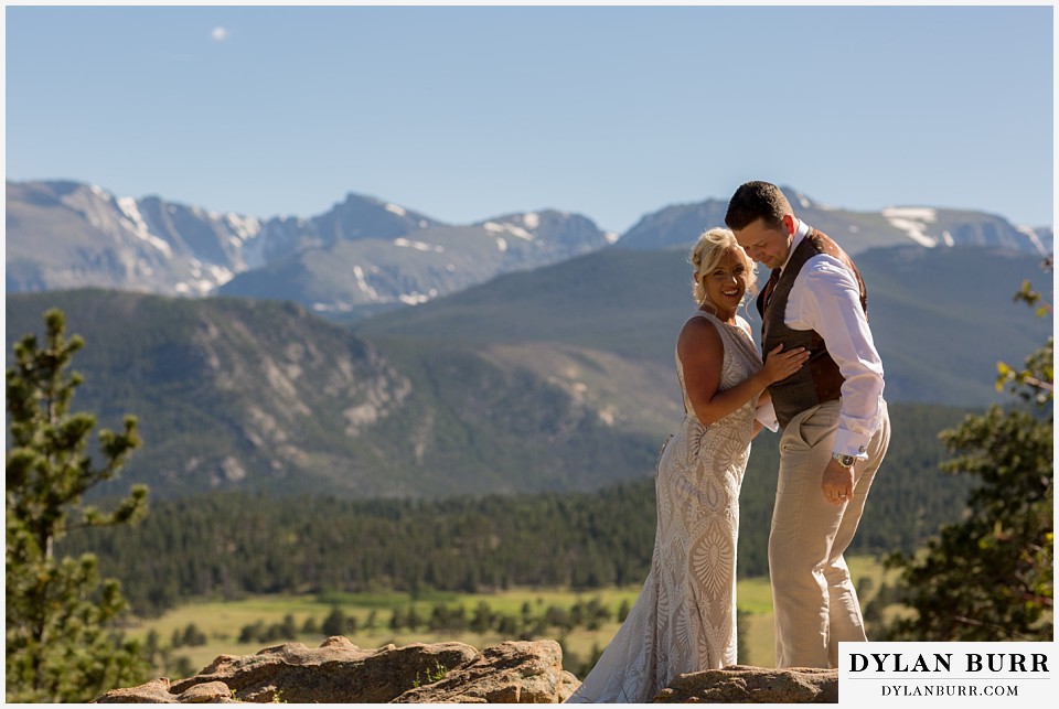 rocky mountain national park wedding elopement happy just married bride and groom standing on rock ledge