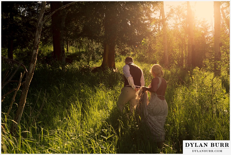 rocky mountain national park wedding elopement bride groom walking in tall grass in sunlight
