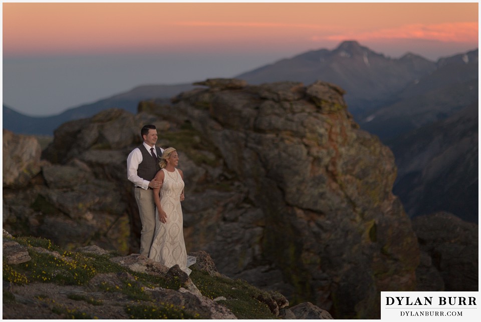 rocky mountain national park wedding elopement bride and groom watching the sunset from the top of the mountains in the wind