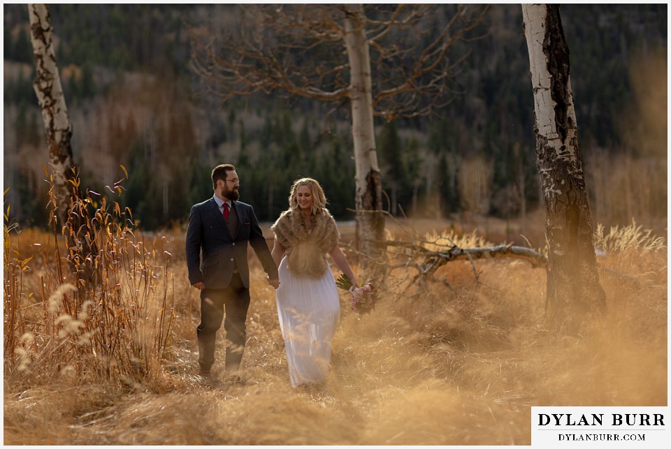 rocky mountain national park wedding elopement bride and groom walking in mountain meadow