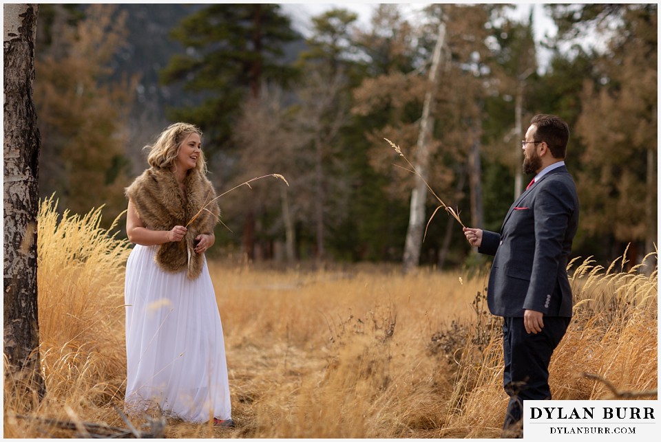 rocky mountain national park wedding elopement bride and groom sword fighting with long grass