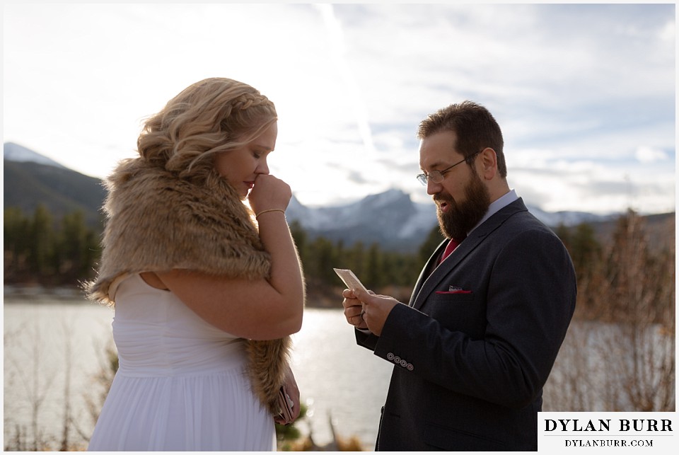 rocky mountain national park wedding elopement groom reading wedding vows to bride in mountains