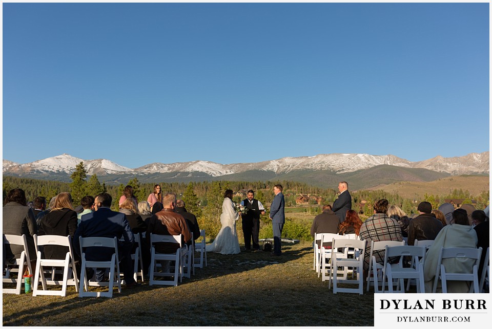 bride and groom reading vows with mountains in background