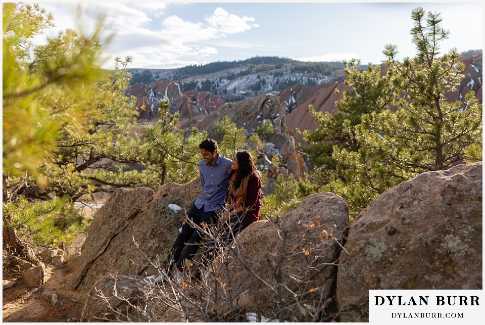roxborough state park engagement photo session couple spending time together sitting on rocks in pine trees