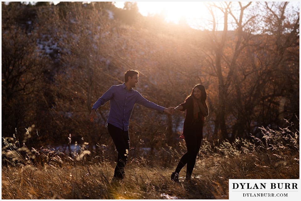 roxborough state park engagement photo session indian couple dancing in meadow at sunset