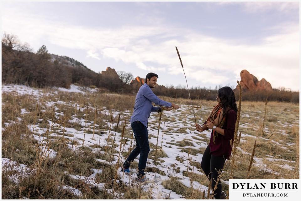 roxborough state park engagement photo session couple fighting with cattails