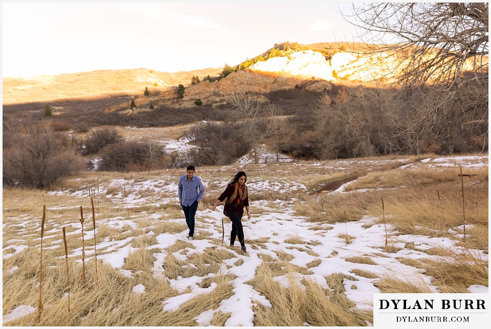roxborough state park engagement photo session walking in snowy and grassy meadow