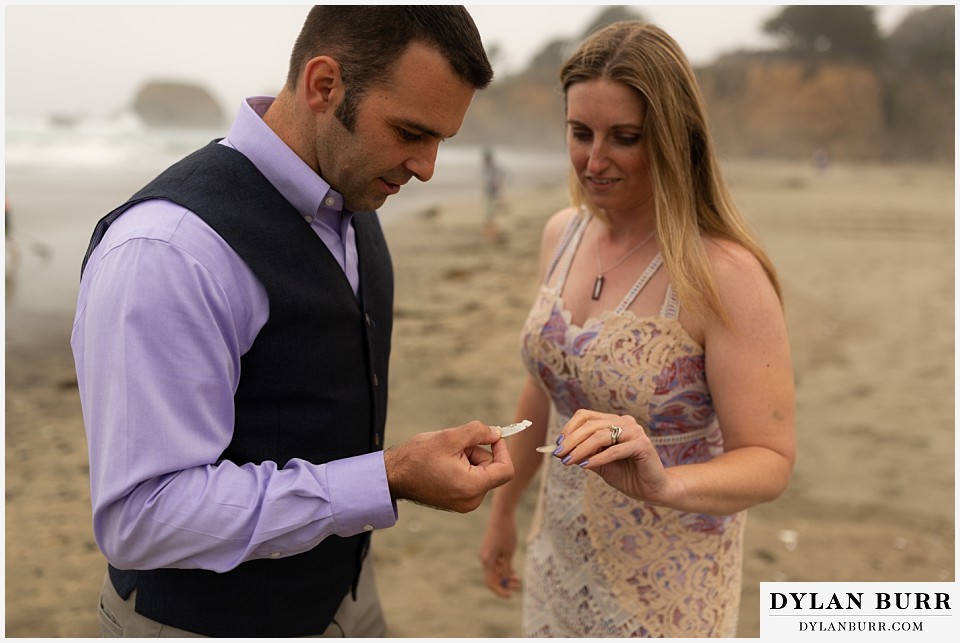 santa cruz california elopement wedding adventure bride and groom comparing seashells