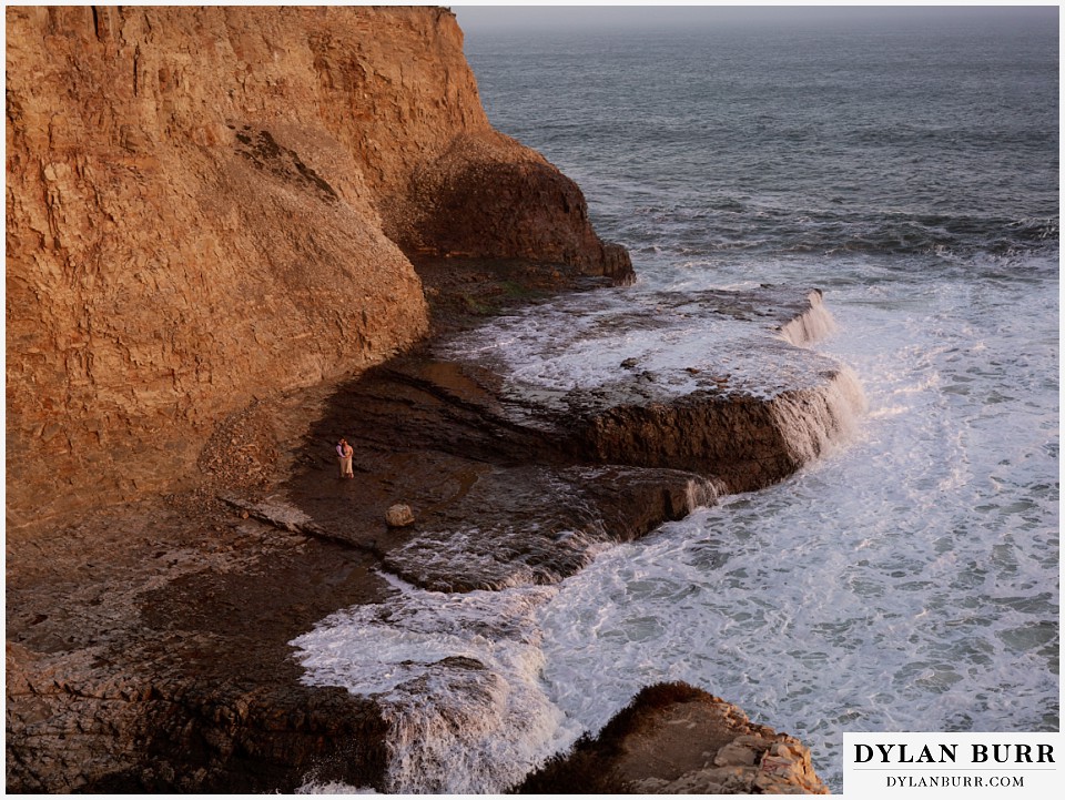 santa cruz california elopement wedding adventure bride and groom on cliff beach as the tide comes in