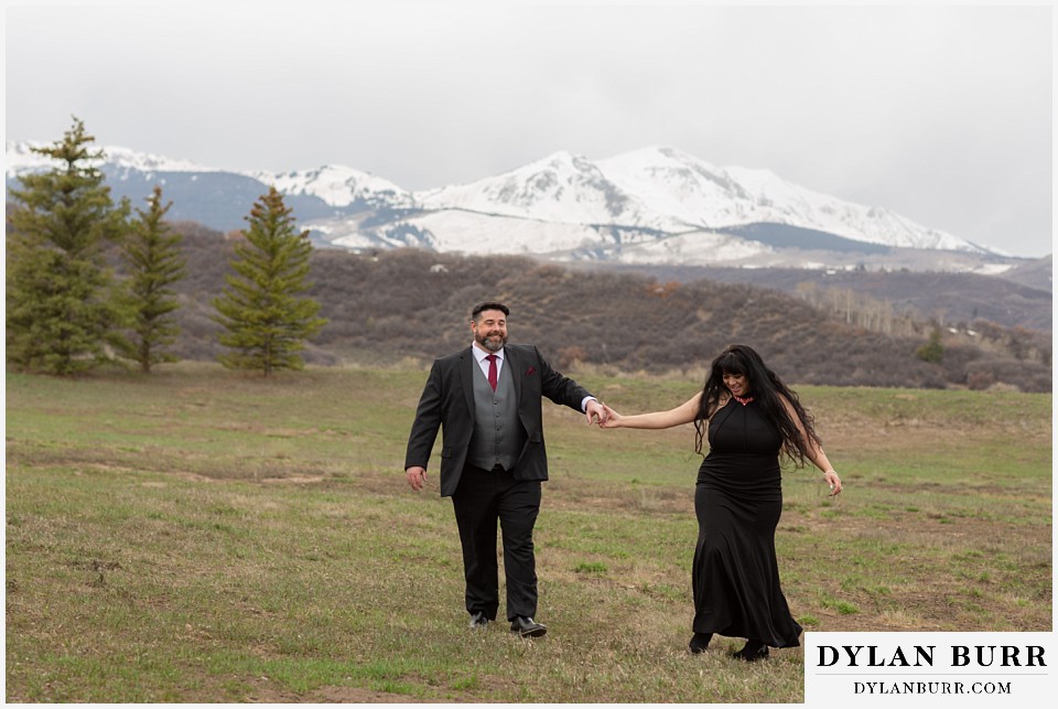 snowmass colorado wedding elopement bride and groom hand in hand with mountains in the background