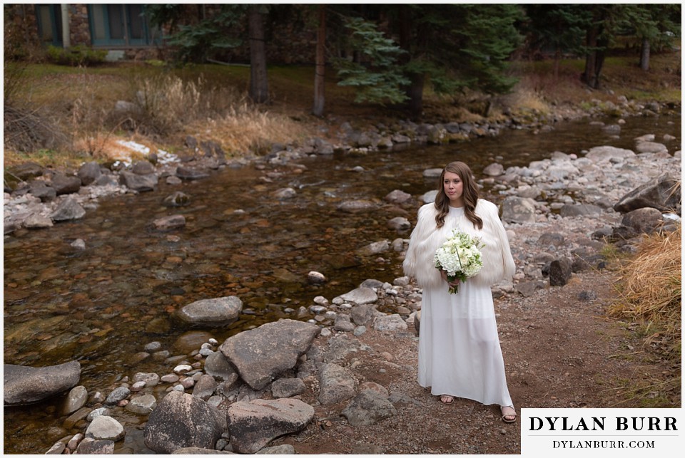 sonnenalp vail wedding bride standing along creek