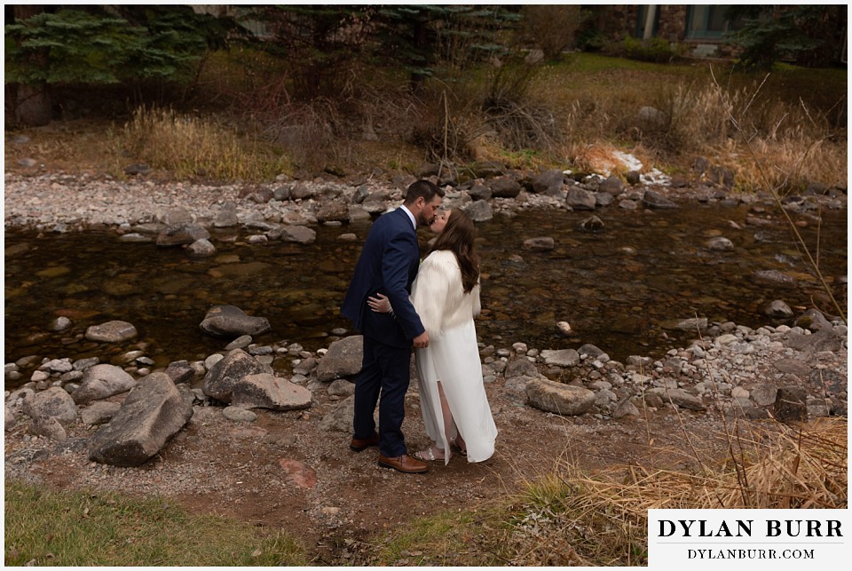 sonnenalp vail wedding bride and groom kissing along creek