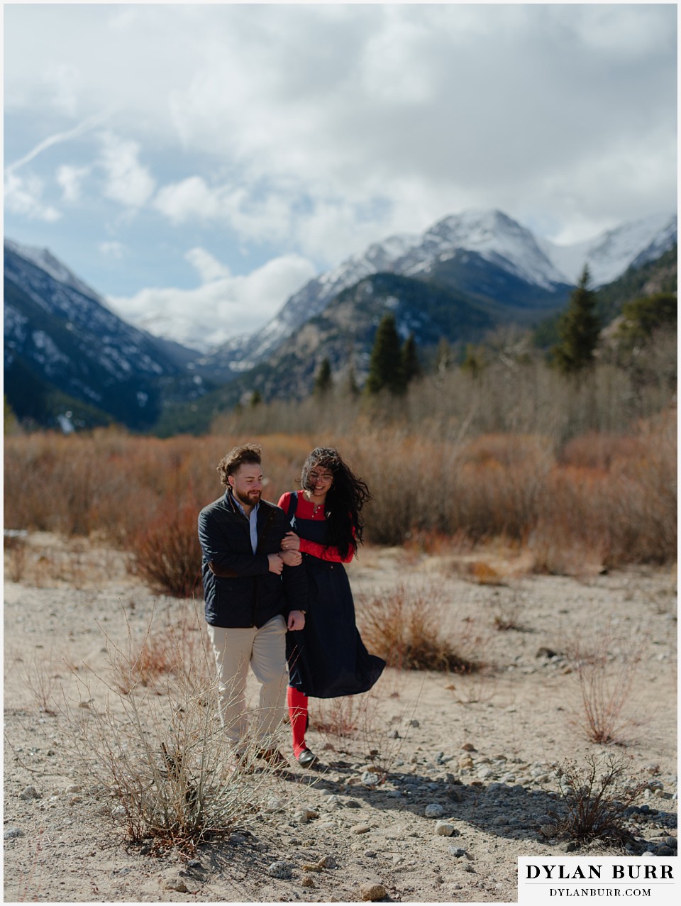couple walking together in mountains in a dry river bed