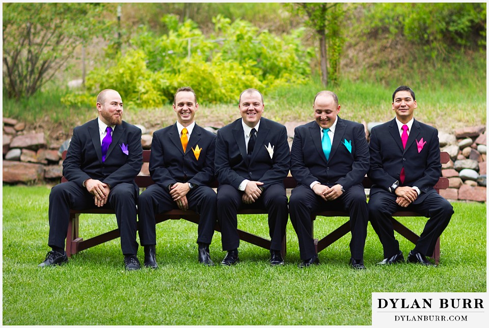 stone mountain lodge wedding groom and groomsmen sitting on bench