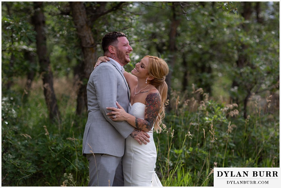 bride and groom laughing in the oak trees