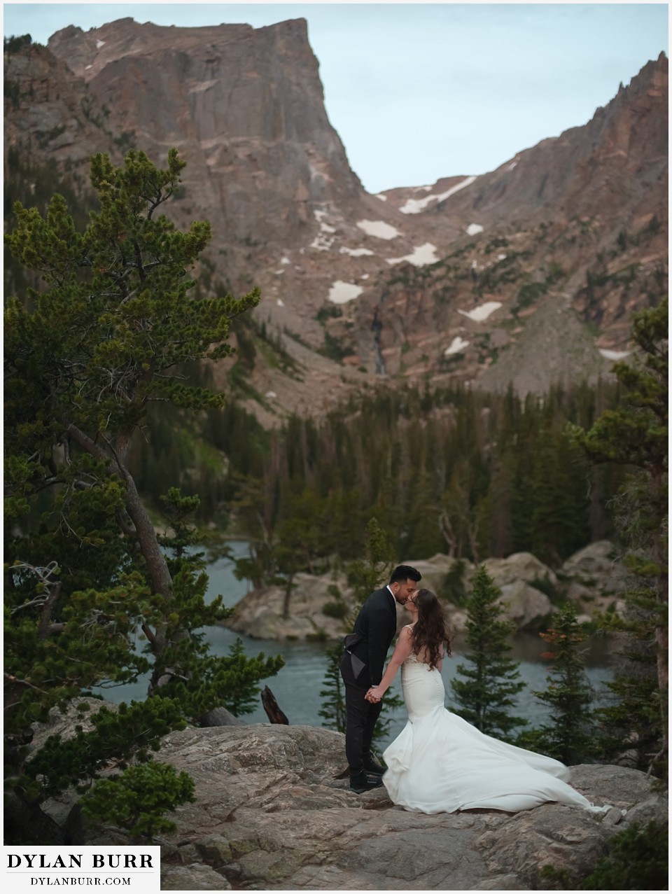 sunrise hike elopement to dream lake kissing at the lake before the sun comes up
