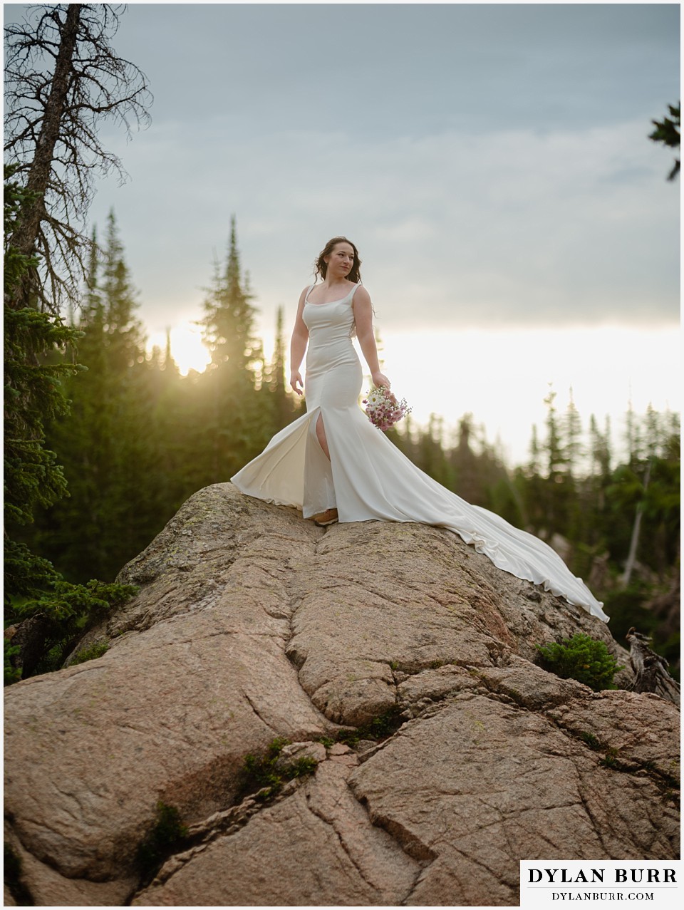 sunrise hike elopement to dream lake gorgeous bride alone on rocks at sunrise