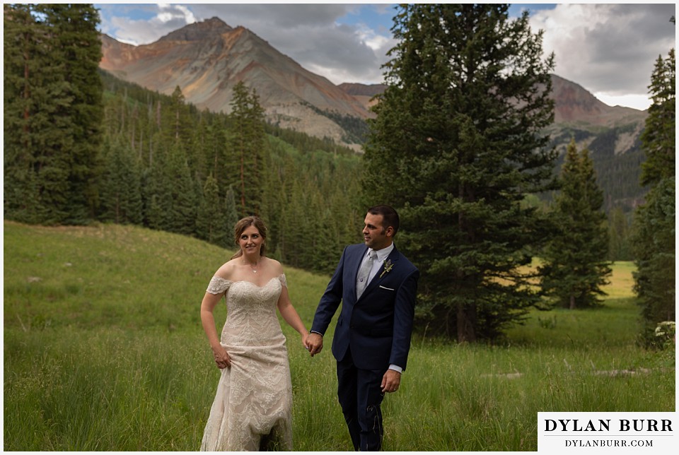 telluride colorado elopement wedding adventure bride and groom walking in a mountain meadow