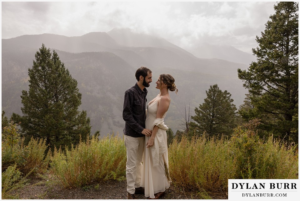 telluride trout lake elopement wedding bride and groom with big mountain view with stormy clouds and rain