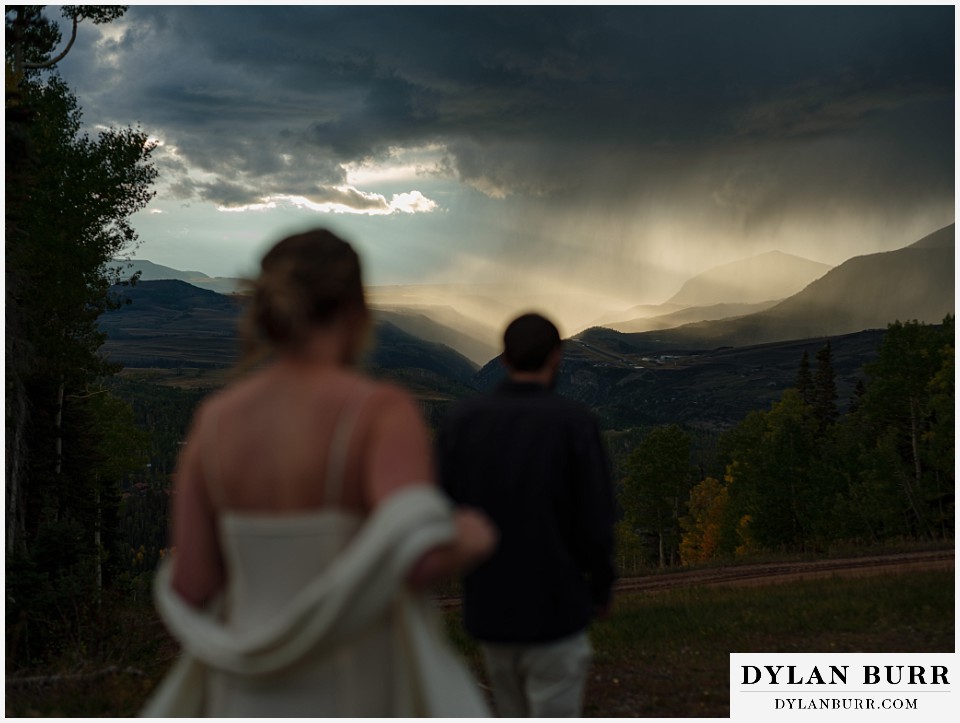 telluride elopement wedding couple walking in mountains with sunset rain in distance
