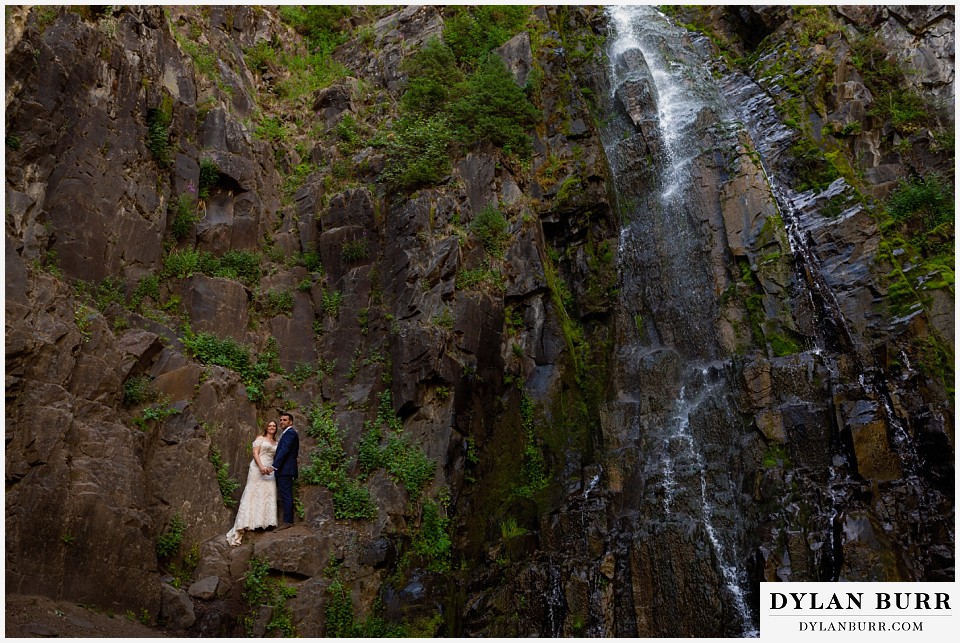 uncompahgre national forest colorado elopement wedding adventure bride and groom wide shot with couple standing on rock wall