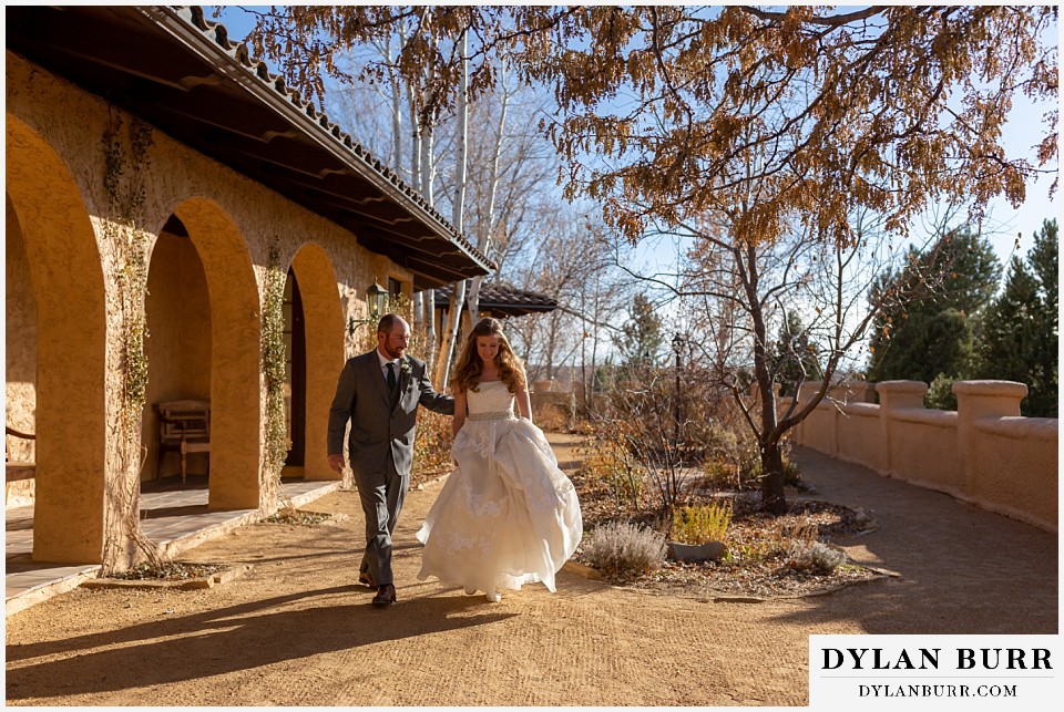 villa parker wedding parker colorado bride and groom walking along arches