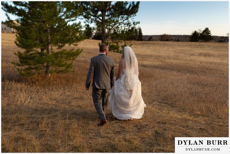 villa parker wedding parker colorado bride and groom walking in field