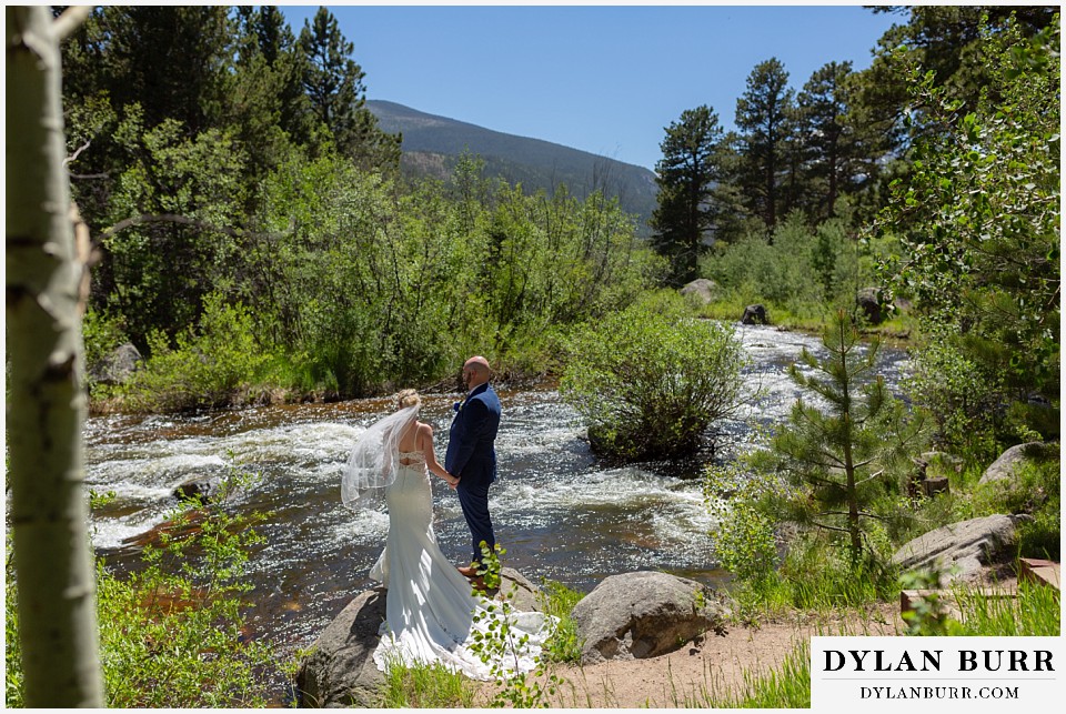 wild basin lodge wedding couple alongside the river