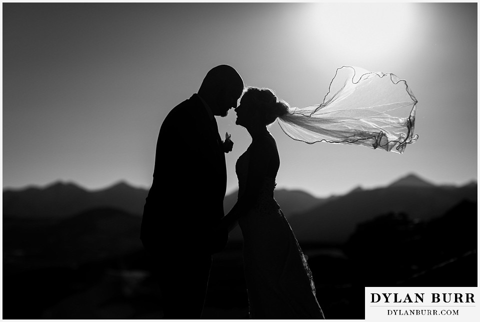 mountain wedding bride and groom in silhouette veil flying in air