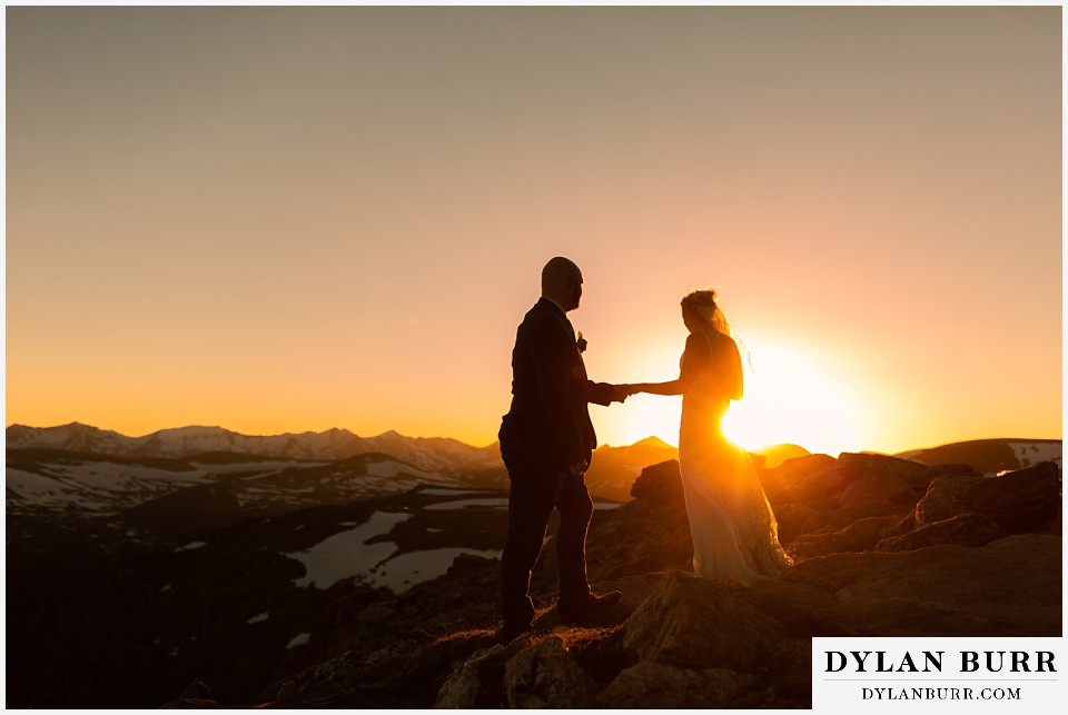 bride and groom walking on mountain top in colorado