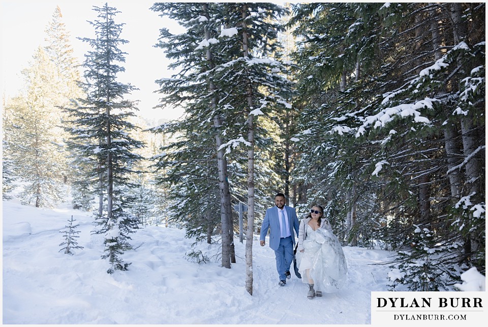 winter elopement wedding near winter park colorado walking up trail in snow