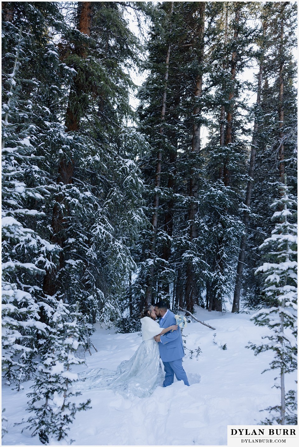 winter elopement wedding near winter park colorado first kiss in tall pine forest