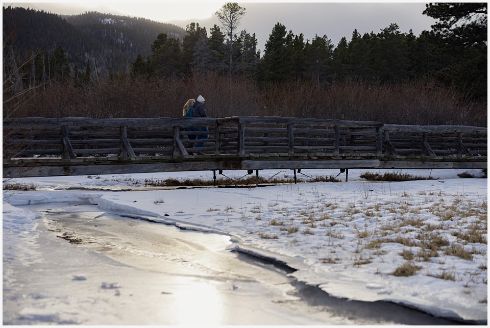 engagement photos couple crossing frozen river together
