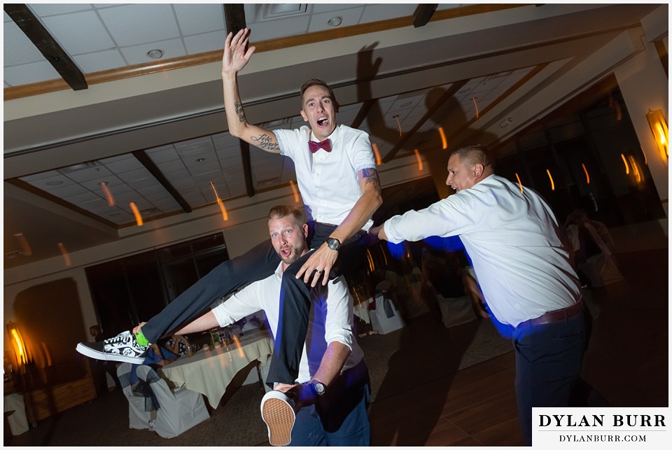 winter park mountain lodge wedding colorado groomsmen picked up groom and riding him around the dance floor